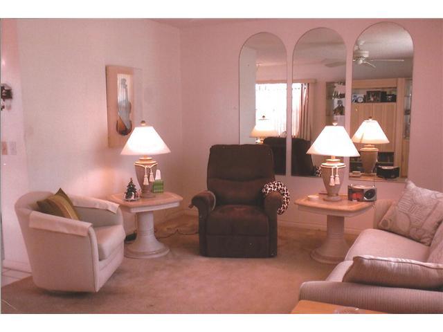 409 Saxony Way, Unit 409 Delray Beach, FL 33446 - Photo 7 of 8 a living room with furniture and a lamp