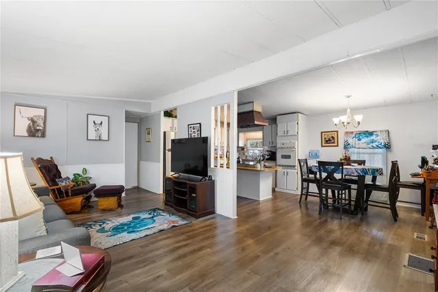 a living room with furniture a dining table and a refrigerator