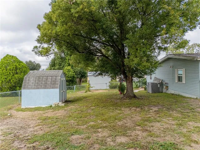 a front view of a house with garden and trees