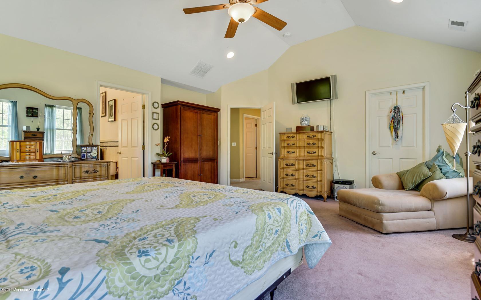 460 North County Line Road Jackson, NJ 08527 - Photo 31 of 48 a spacious bedroom with a bed a couch and a chandelier