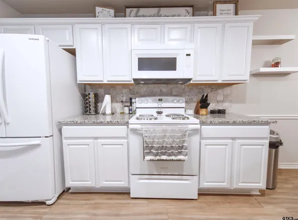 a kitchen with stainless steel appliances white cabinets and a sink