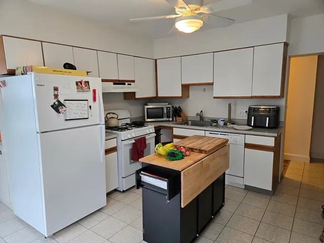 a kitchen with a white stove top oven and white cabinets