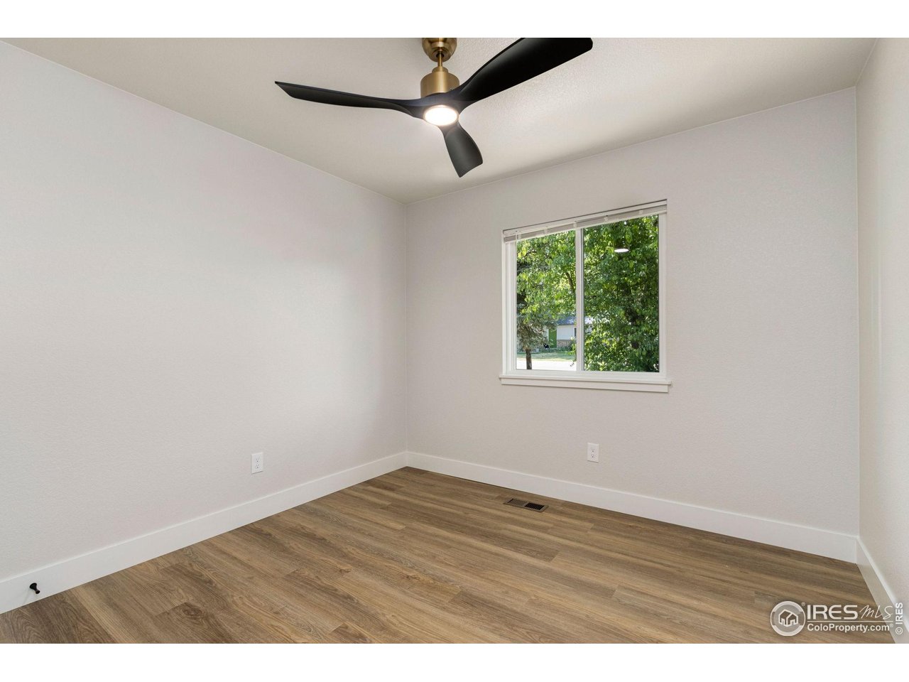 812 Rocky Road Fort Collins, CO 80521 - Photo 15 of 19 an empty room with wooden floor and windows
