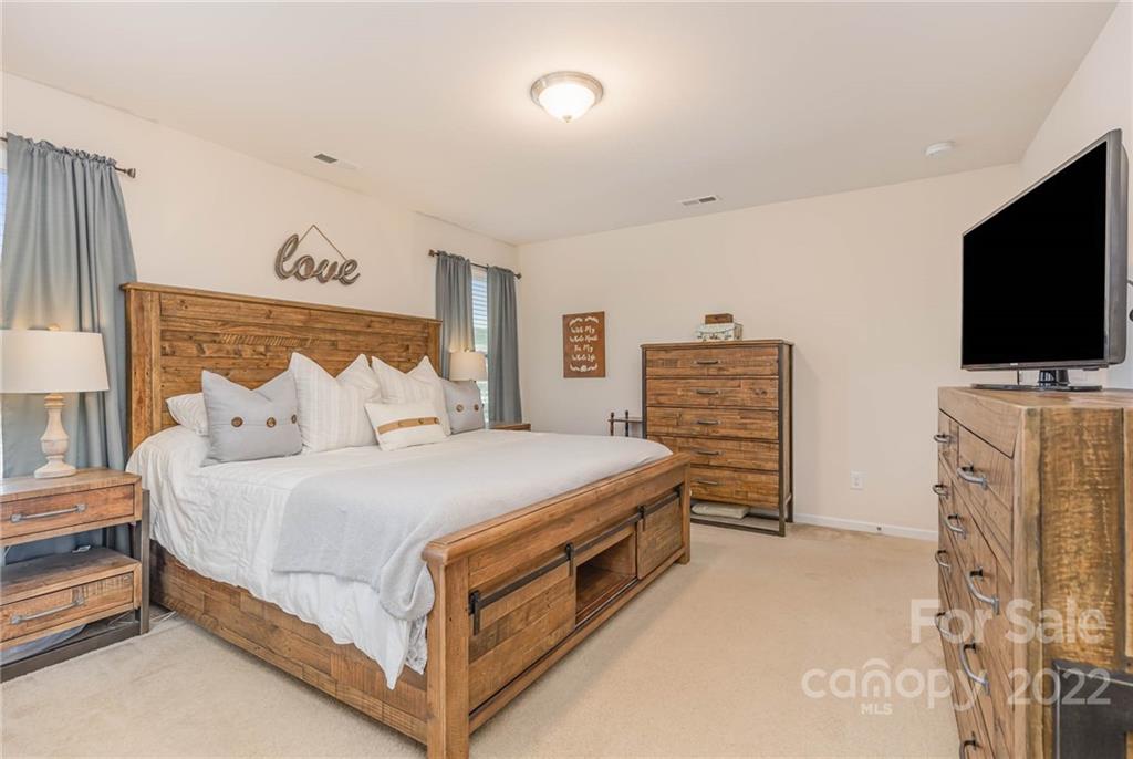 1563 Spring Blossom Trail Fort Mill, SC 29708 - Photo 12 of 25 a bed room with furniture and a flat screen tv