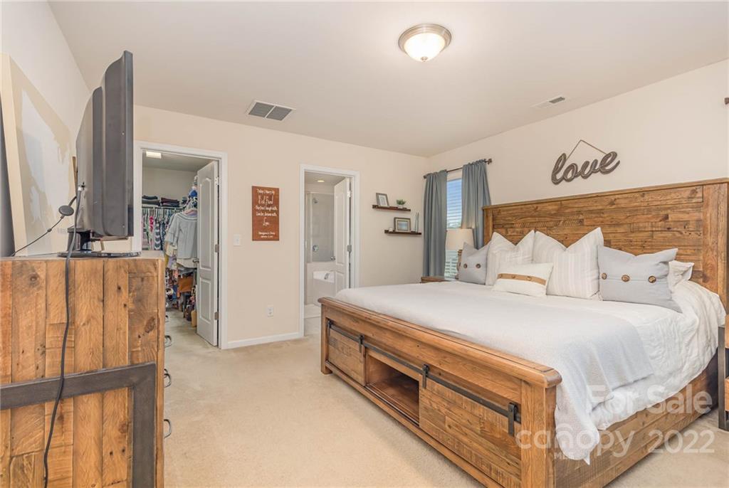 1563 Spring Blossom Trail Fort Mill, SC 29708 - Photo 13 of 25 a spacious bedroom with a bed and a table