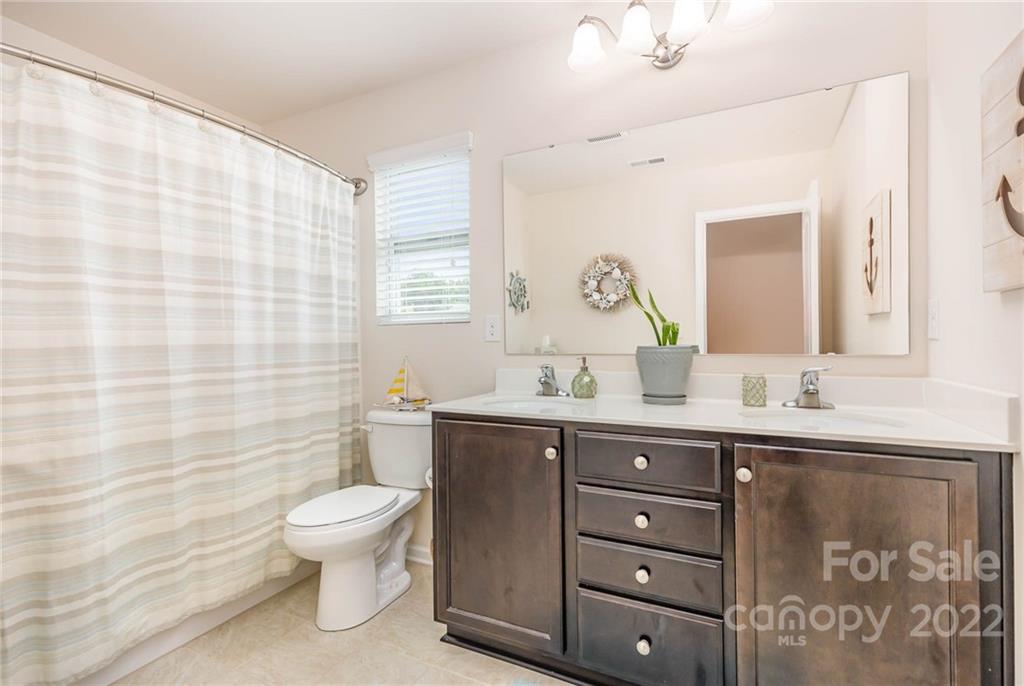 1563 Spring Blossom Trail Fort Mill, SC 29708 - Photo 19 of 25 a spacious bathroom with a granite countertop sink a toilet and a mirror