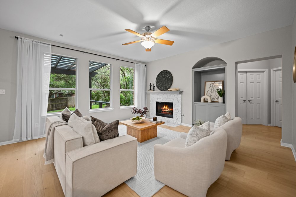 2823 Lantana Ridge Drive Austin, TX 78732 - Photo 8 of 34 a living room with furniture a fireplace and a large window