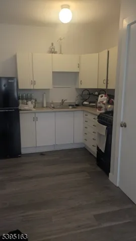 a kitchen with granite countertop white cabinets and stainless steel appliances