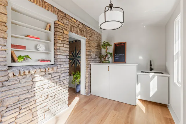 a view of a hallway with wooden floor and a chandelier