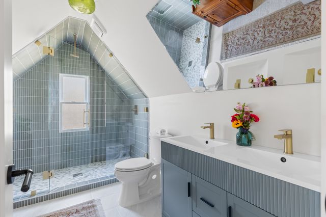 a bathroom with a sink a toilet and shower