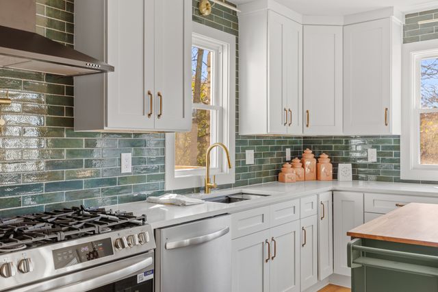 a kitchen with stainless steel appliances granite countertop a sink stove and cabinets
