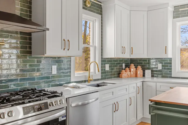 a kitchen with stainless steel appliances granite countertop a sink stove and cabinets
