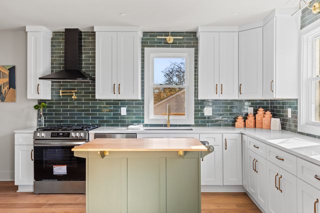 a kitchen with stainless steel appliances granite countertop a sink stove and cabinets