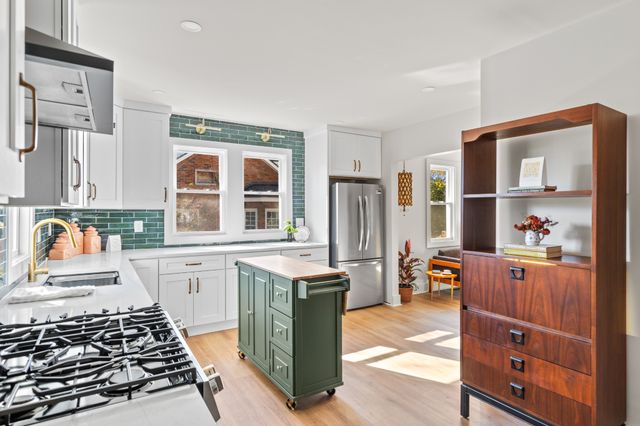 a kitchen with stainless steel appliances a stove a sink and a refrigerator