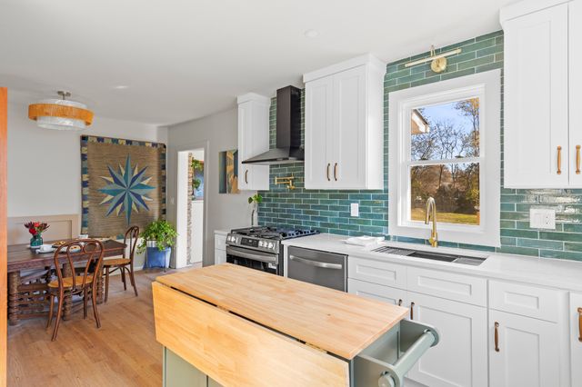 a kitchen with stainless steel appliances a stove a sink and a refrigerator