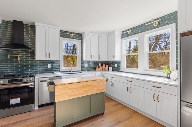 a kitchen with stainless steel appliances granite countertop a stove and a sink