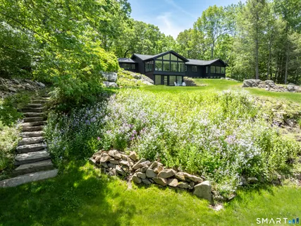 a view of a house with a yard and sitting area
