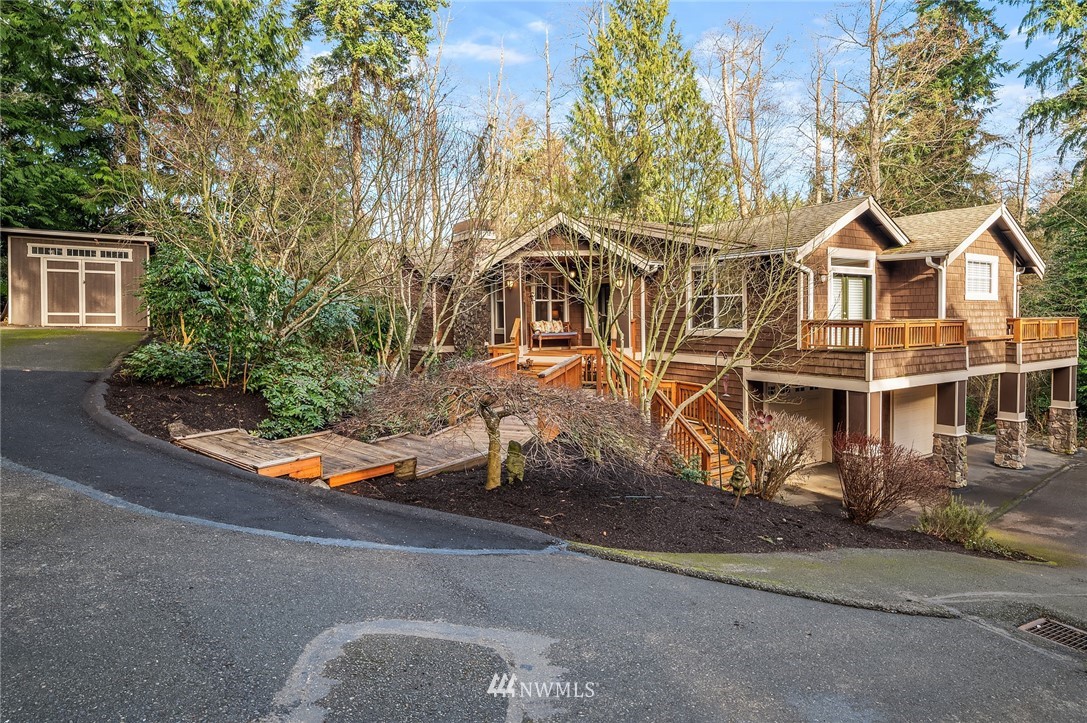9203 Park Road Edmonds, WA 98020 - Photo 3 of 40 a view of a white house with large trees and plants next to a road