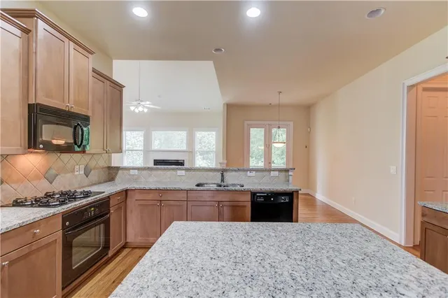 a kitchen with stainless steel appliances granite countertop a stove a sink and a microwave