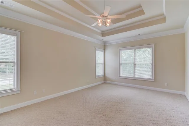 an empty room with a ceiling fan and windows