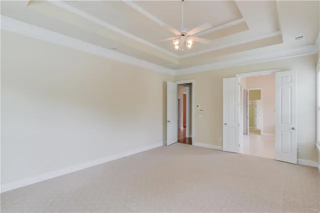 an empty room with a ceiling fan and window