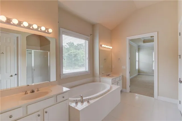 a bathroom with a tub a sink and mirror