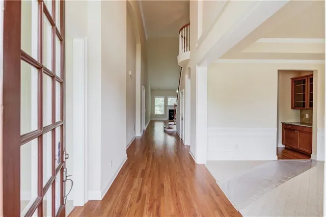 a view of a hallway with wooden floor and staircase
