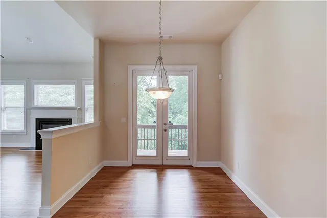 a view of an empty room with window and wooden floor