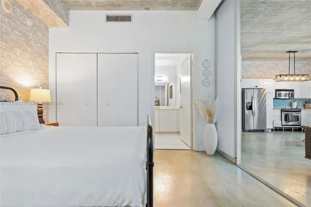 a bedroom with a bed and a view of kitchen