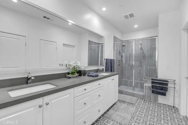 a spacious bathroom with double sink and a mirror