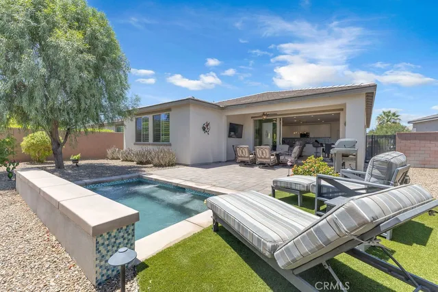 a view of a house with swimming pool and furniture
