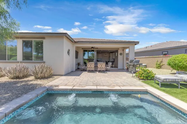 a view of a patio with table and chairs potted plants and floor to ceiling window