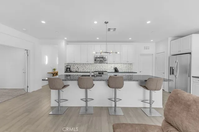 a kitchen with a dining table chairs sink and cabinets