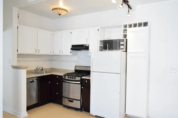a kitchen with stainless steel appliances a refrigerator sink and cabinets