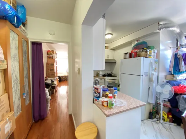 a kitchen view with appliances a refrigerator and a dining table