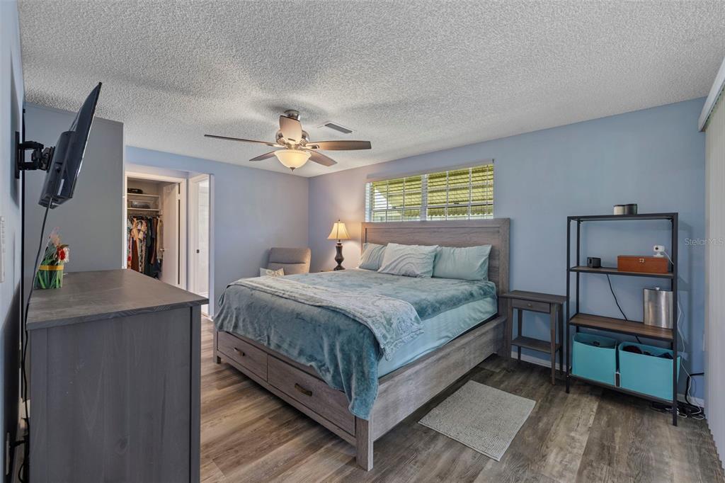 12111 Fieldstone Lane Hudson, FL 34667 - Photo 13 of 49 a bedroom with a bed and a chandelier