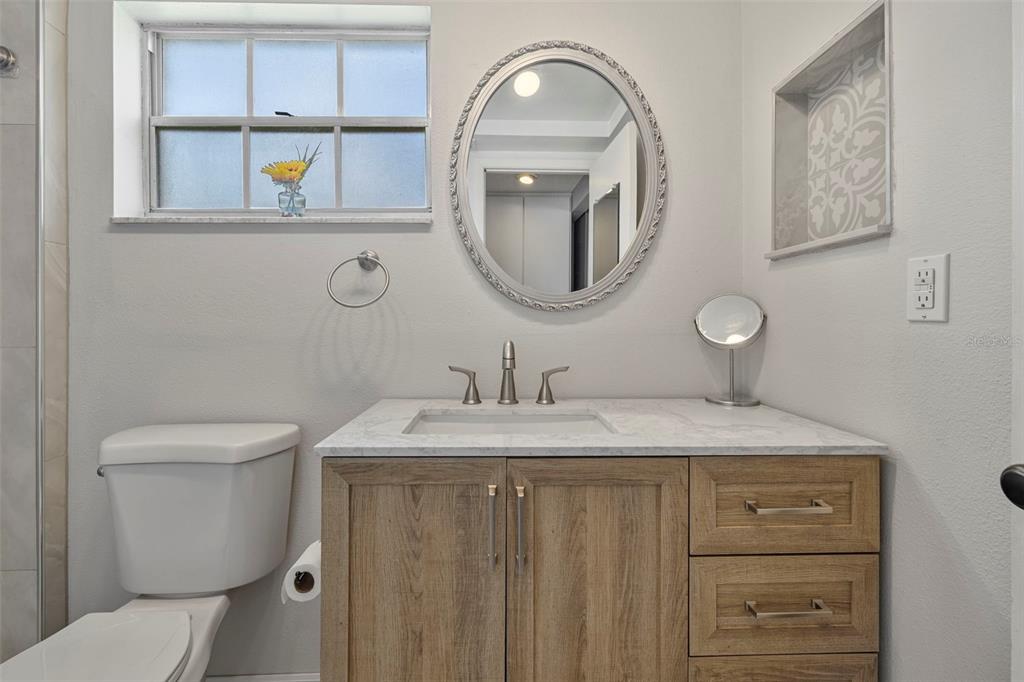 12111 Fieldstone Lane Hudson, FL 34667 - Photo 15 of 49 a bathroom with a granite countertop toilet a sink and mirror