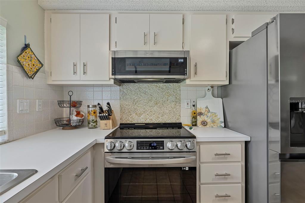 12111 Fieldstone Lane Hudson, FL 34667 - Photo 18 of 49 a kitchen with stainless steel appliances granite countertop white cabinets and a stove