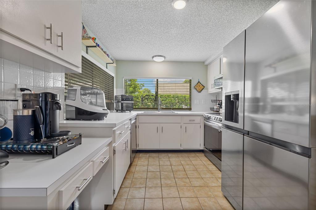 12111 Fieldstone Lane Hudson, FL 34667 - Photo 3 of 49 a kitchen with a sink stainless steel appliances a counter top space cabinets and stainless steel appliances