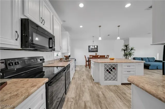 a view of a dining room and livingroom with furniture wooden floor a chandelier