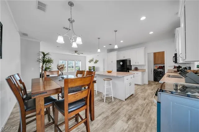 a kitchen with a refrigerator stove and white cabinets with wooden floor