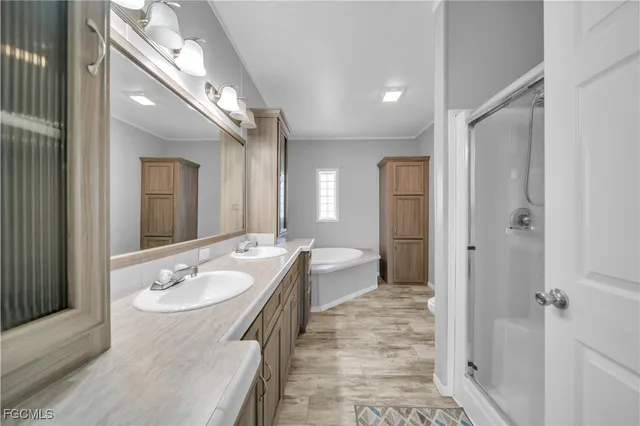 a bathroom with a bathtub a mirror a sink and a window