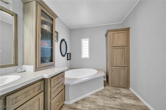 a spacious bathroom with a shower a sink and a mirror