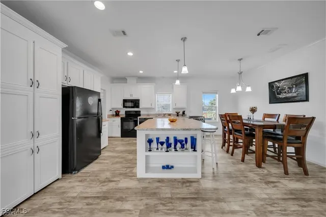 a kitchen with stainless steel appliances kitchen island granite countertop a stove a sink and a microwave