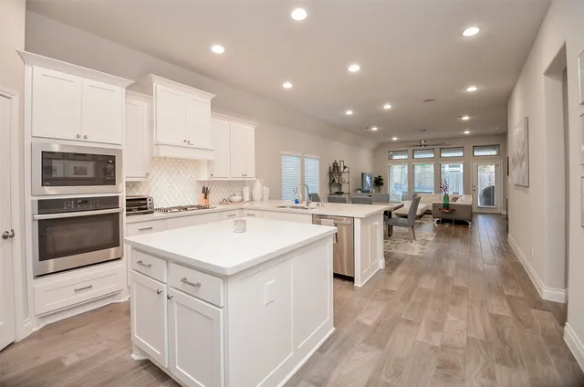 a kitchen with white cabinets and stainless steel appliances