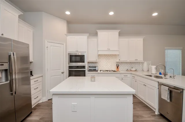 a kitchen with a sink a refrigerator and cabinets