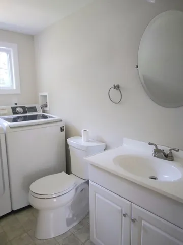 a bathroom with a toilet a sink and a mirror