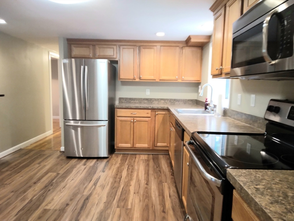 42 Lowell Road Pepperell, MA 01463 - Photo 8 of 32 a kitchen with a refrigerator stove and wooden floor