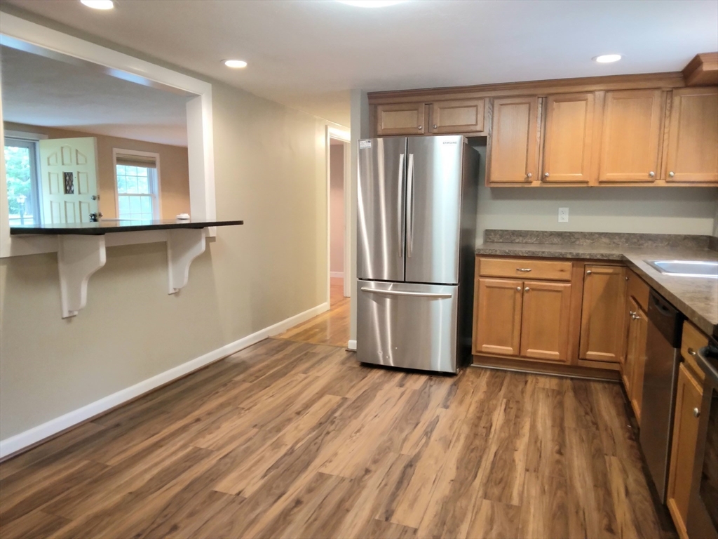 42 Lowell Road Pepperell, MA 01463 - Photo 9 of 32 a kitchen with kitchen island wooden floors appliances and cabinets