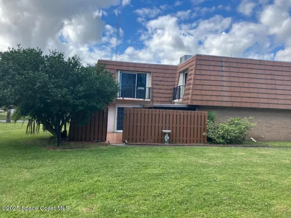 a view of a house with a yard and fence